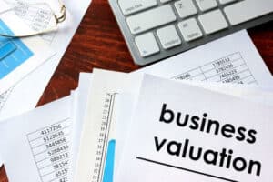 Business valuation paperwork next to a computer